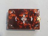 a small tortoise shell wallet with a gold clasp
