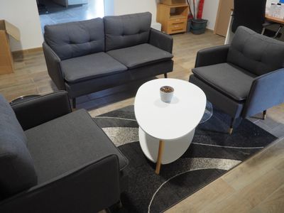 une photo d'un salon avec deux fauteuils et une table