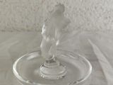a glass cup that has a glass figurine on it
