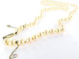 collier avec des perles et un fermoir en or sur fond blanc