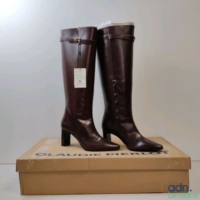 a pair of brown boots sitting on top of a cardboard box