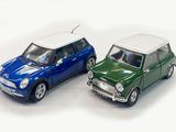 two miniature cars sitting side by side on a white surface