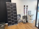 une photo d'un salon de coiffure avec une enseigne et un poteau de coiffeur