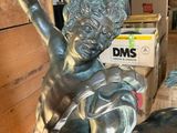 a statue of a boy riding a bull in a room