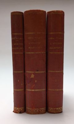 trois livres rouges superposés sur une surface blanche