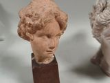 two statues of women with curly hair are sitting next to each other
