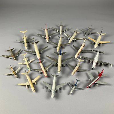 de nombreux modèles réduits d'avions disposés en cercle sur une surface grise