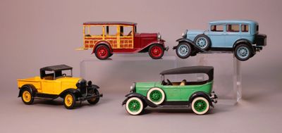 three different model cars on display on a clear stand