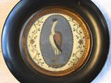 a picture of a bird on a plate on a table