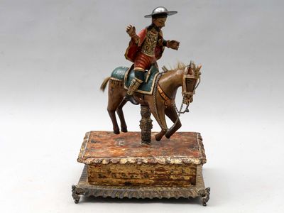 une figurine représentant un homme à cheval, posée sur une boîte