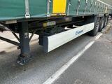 un semi-remorque vert avec une remorque jaune à l'arrière