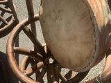 a drum sitting on top of a chair next to a dog
