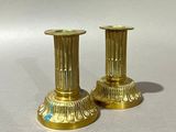 pair of antique brass candlesticks on a white background