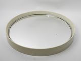 a close up of a round mirror on a white surface