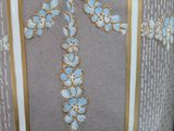 a vase with a gold border and blue flowers on it
