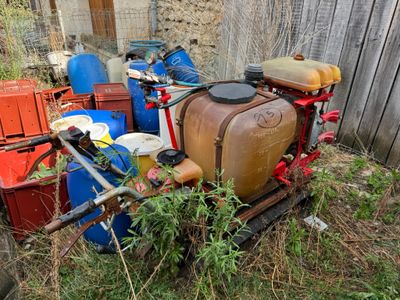 a lot of trash in the yard next to a fence