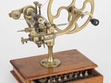 une machine à coudre ancienne posée sur un support en bois, avec un tiroir en dessous