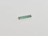 a green tourmaline stone on a white surface