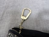 a small zipper bag with a keychain on top of it