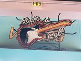 a neon sign for a rock and roll cafe with a guitar on it