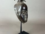 a black and silver sculpture of a bird on top of a head