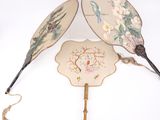 deux éventails ornés de motifs, posés sur une table