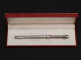 a silver ballpoint pen in a red box on a black surface