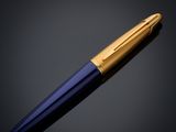 a gold and blue fountain pen on a black background