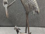 une statue représentant un oiseau tenant un poisson dans le bec