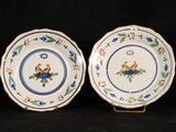 two plates with blue and green designs on them on a black background