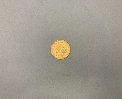 une pièce d'or posée sur une surface grise