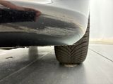 a close up view of a car ' s front bumper and tire