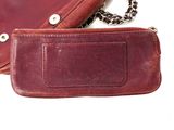 a brown purse with a chain around it on a white surface