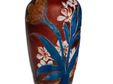 un vase orné d'une fleur bleue sur un fond blanc