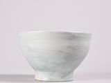 a close up of a white bowl on a white surface