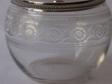 a glass jar with a silver lid sitting on a table