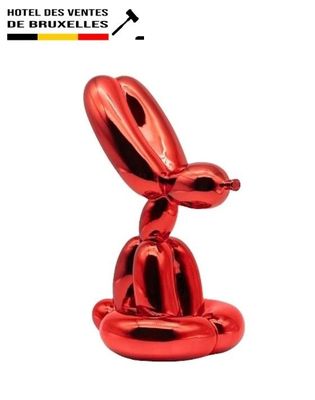 the red balloon dog sculpture is sitting on top of a table