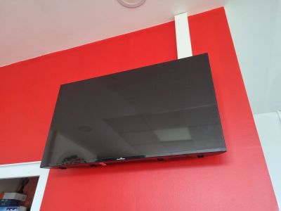 une télévision à écran plat accrochée à un mur rouge
