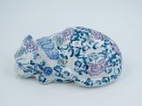 une figurine d'éléphant bleue et blanche posée sur une surface blanche