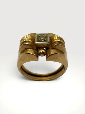 a close up of a gold ring with a square stone in the middle