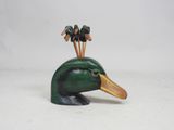 a wooden duck with three birds on top of it
