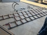 a man sitting on the ground next to a metal bed frame