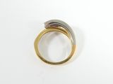 an image of a gold and silver ring sitting on top of a white surface