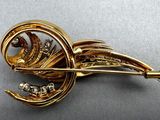 a gold brooch with diamonds on it sitting on a table