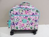 a pink and blue flowered suitcase with wheels on a table