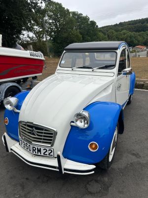 une petite voiture bleue et blanche garée sur un parking