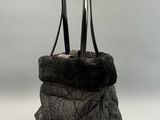 sac en cuir avec une doublure en fourrure noire sur fond blanc