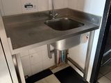 a stainless steel sink in the corner of a kitchen