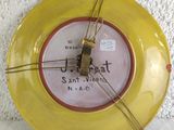 a yellow plate with a clock on it on the wall