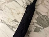 a black umbrella sitting on a marble counter top